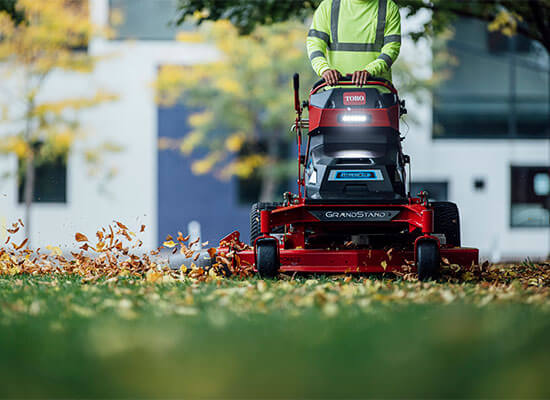 Woman using machine to trim hedges