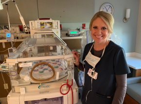 nurse standing beside bassinet