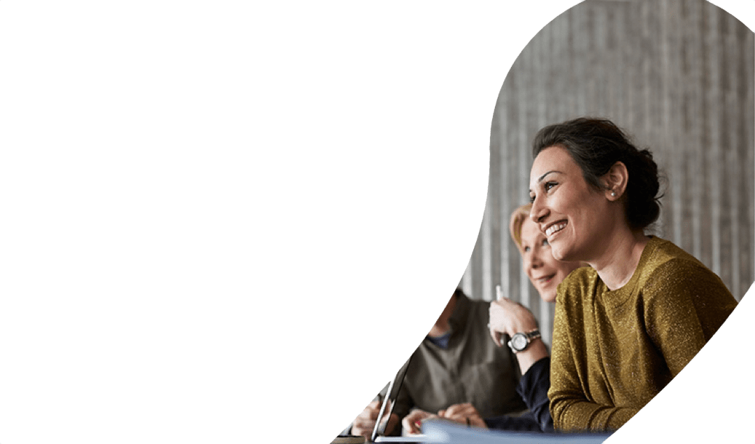 Woman smiling next to colleagues in a meeting