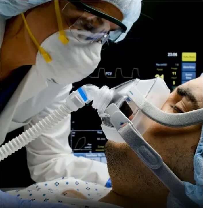 Patient on ventilator while being checked on by a specialist