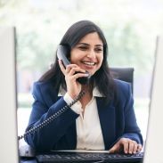 2 people sitting at a table looking at a paper sheet and smiling
