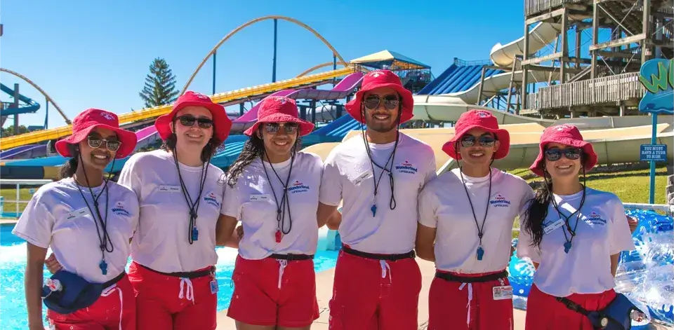 Group of lifeguards posing for a picture in front of Six Flags waterslides