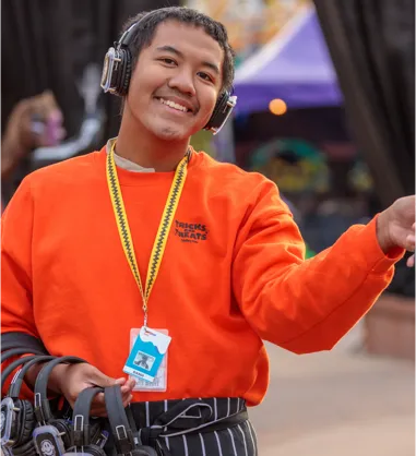 Employee holding headphones and smiling