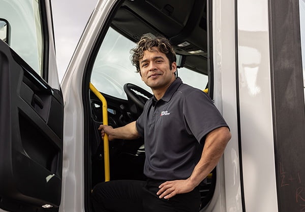 Male employee getting into a delivery truck. 