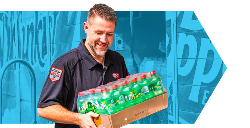 Male employee carrying a case of Seven Up