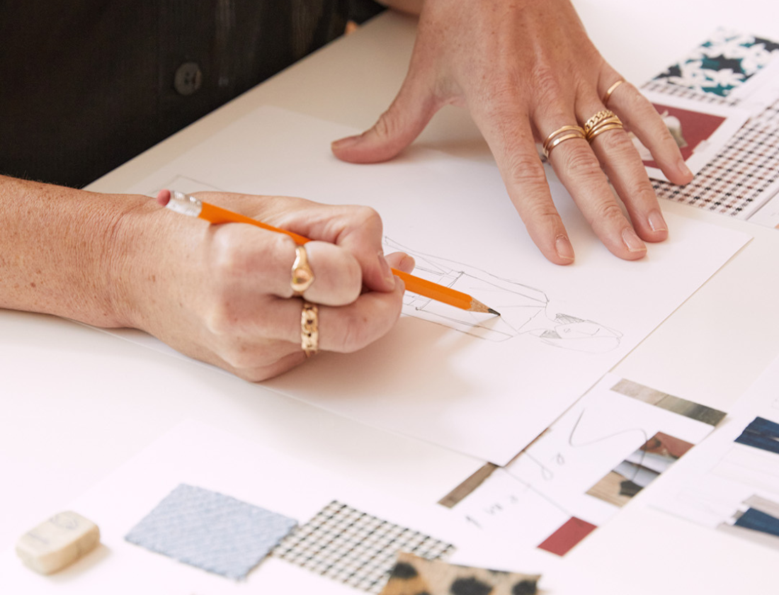 Woman drawing a sketch on white paper.