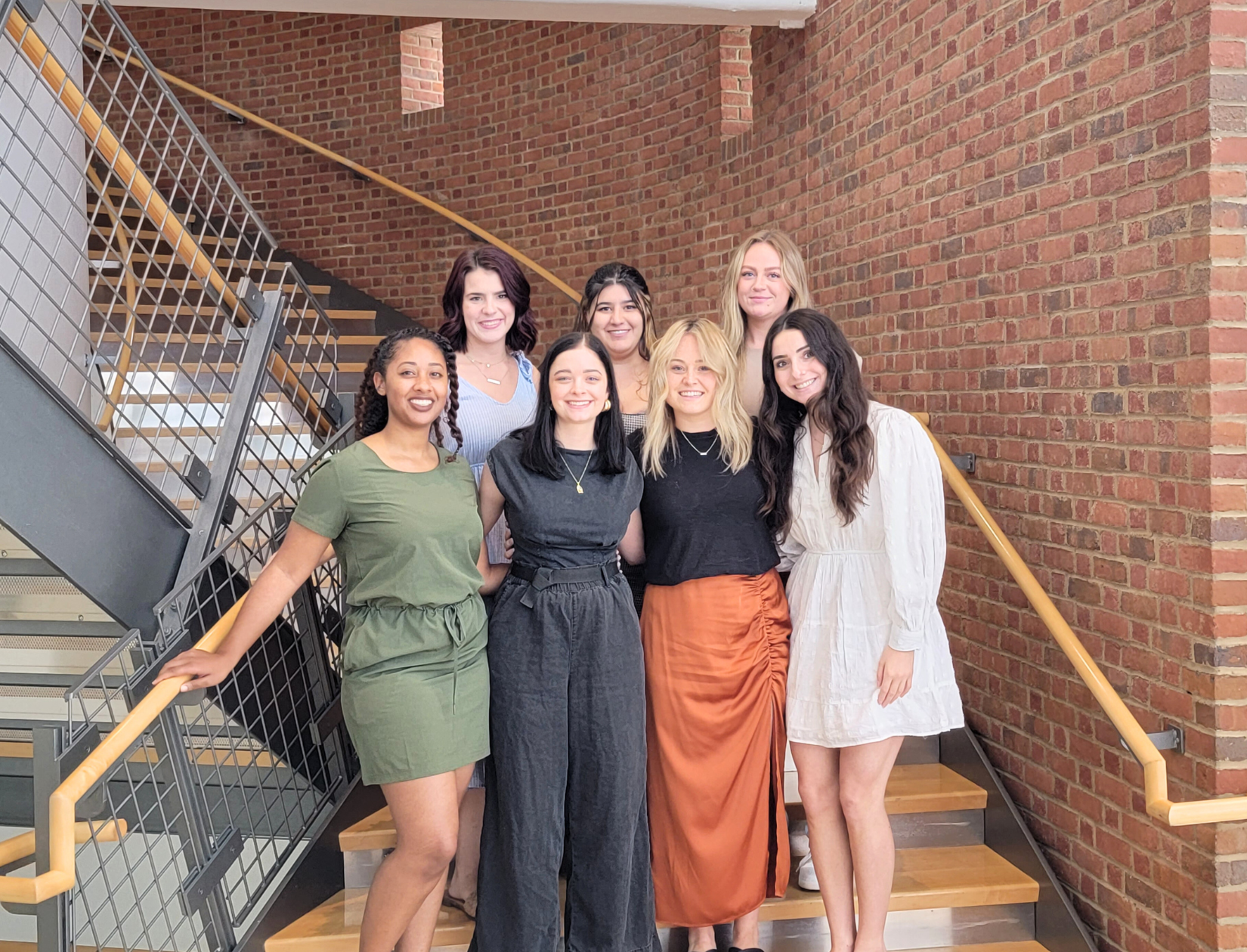 A group of young women standing on a staircase.