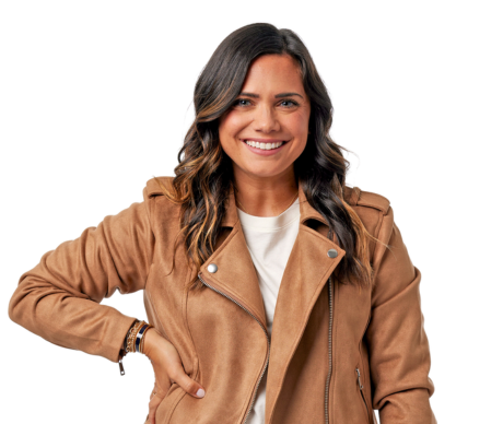 Woman in a suede jacket with hand on hip.