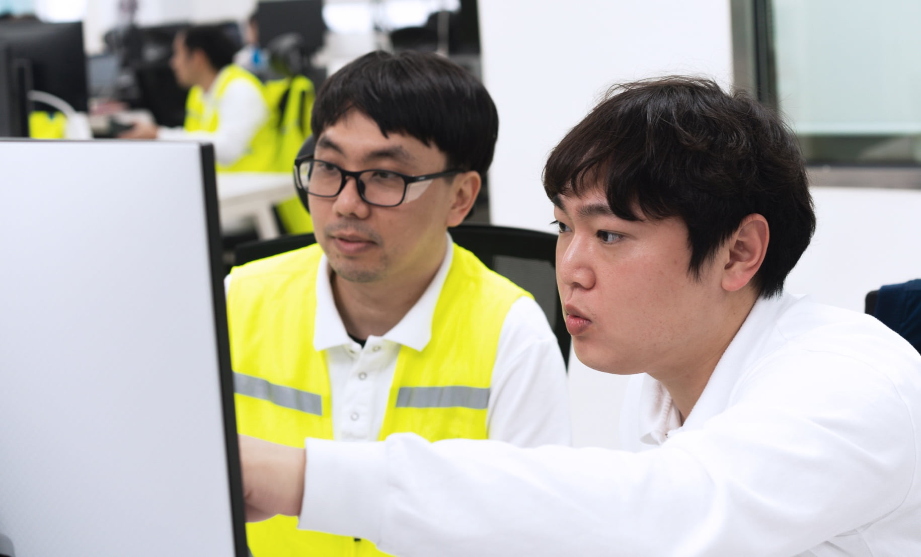 Two employees looking together at a computer monitor.