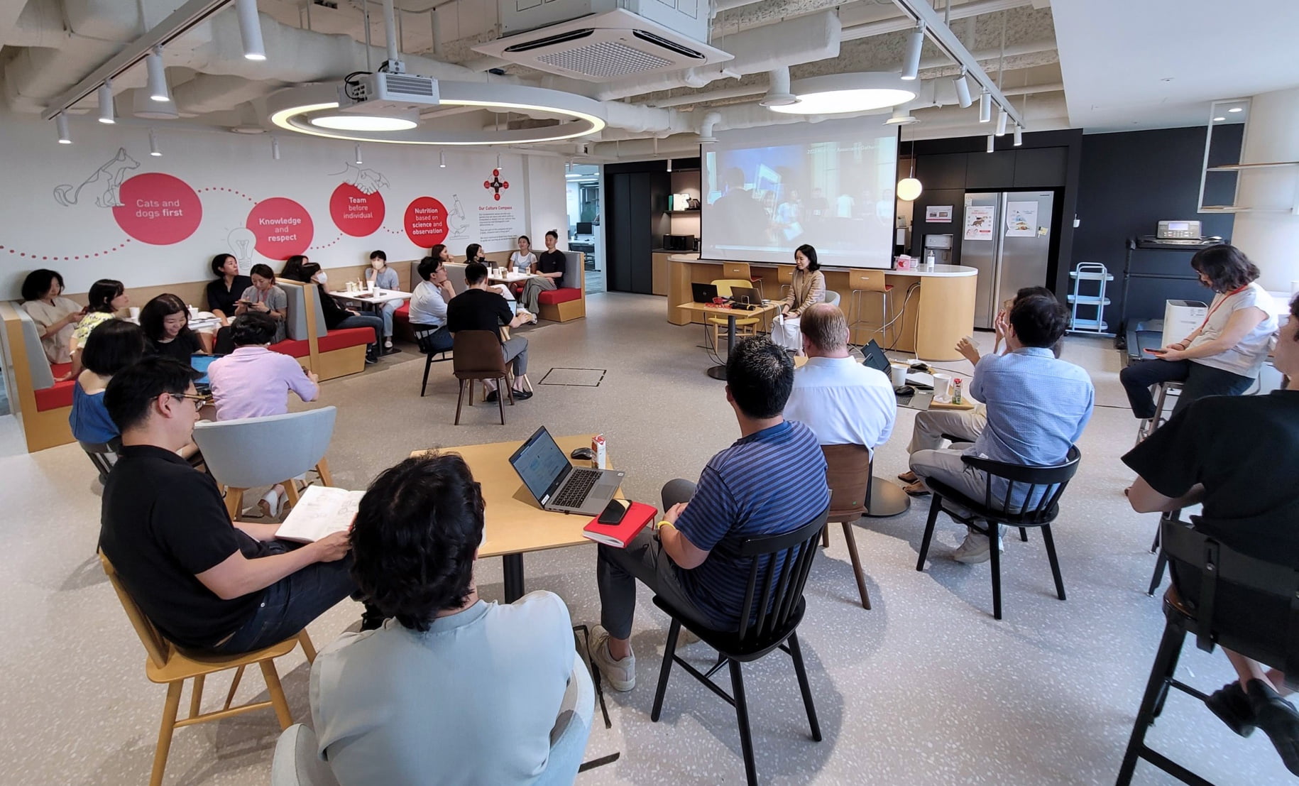 Group of people sitting together and listening to a presentation.