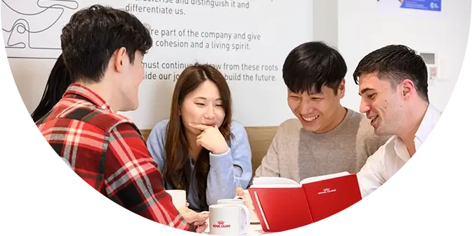 Five people engaging in conversation over coffee