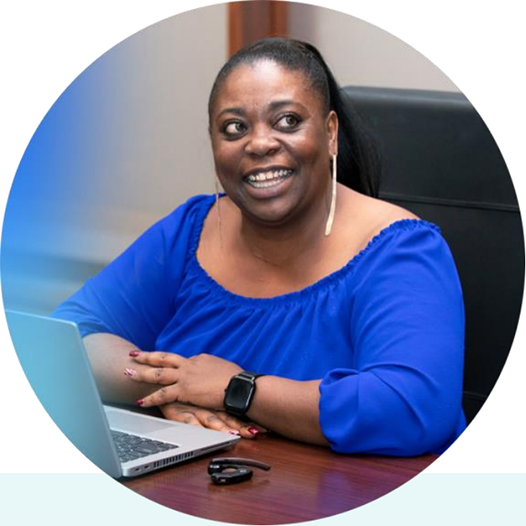 Woman at a table with laptop smiling