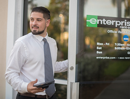 Andres holding open the door to an Enterprise location