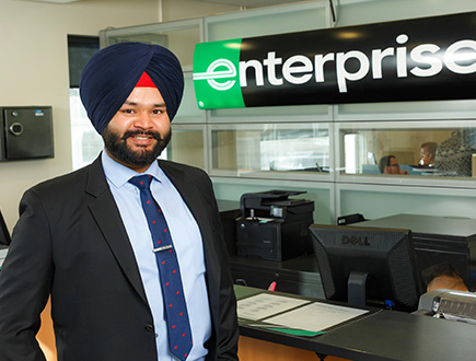 Manmeet standing by welcome desk
