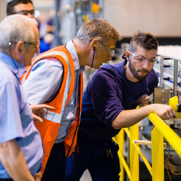 Men wearing protective eye wear observing a machine