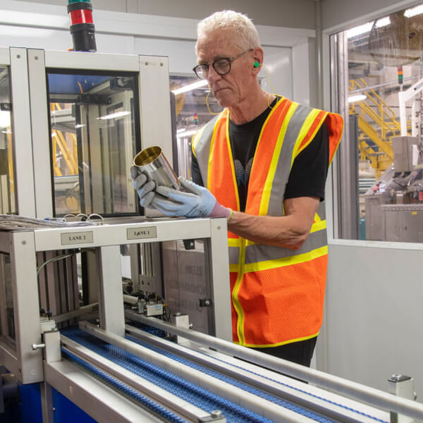 Man observing a tin around machinery