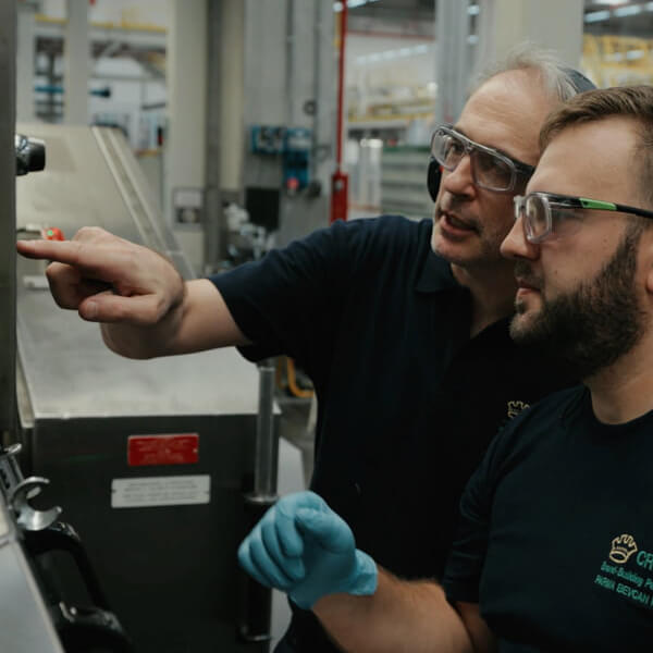 Two men working at a machine