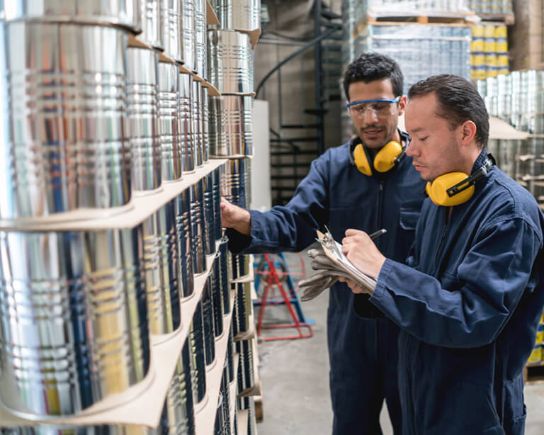 Two men checking work in uniforms with a clipboard