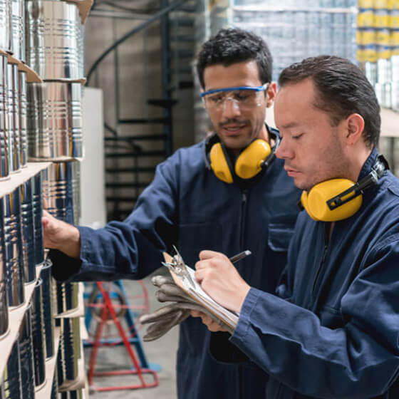 Two men checking work in uniforms with a clipboard