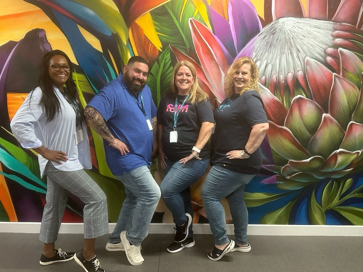 Four TTEC employees posing for the camera in a fun way.