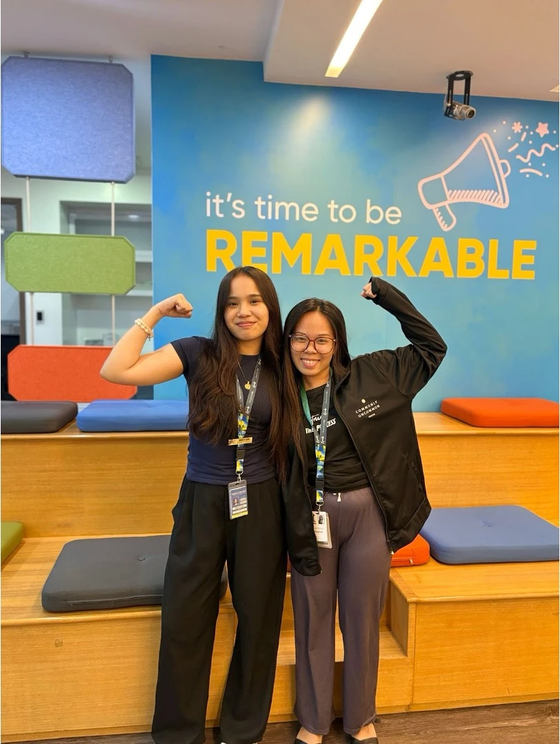 Two TTEC employees flexing their arms.