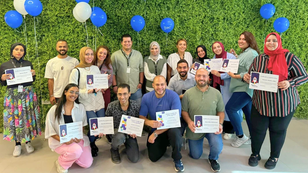 TTEC EMEA team members jolding certificates of recognition.