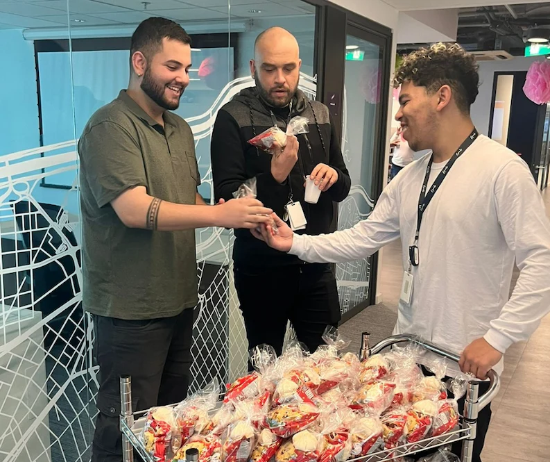 TTEC LATAM Brazil team member handing out treats to other employees.