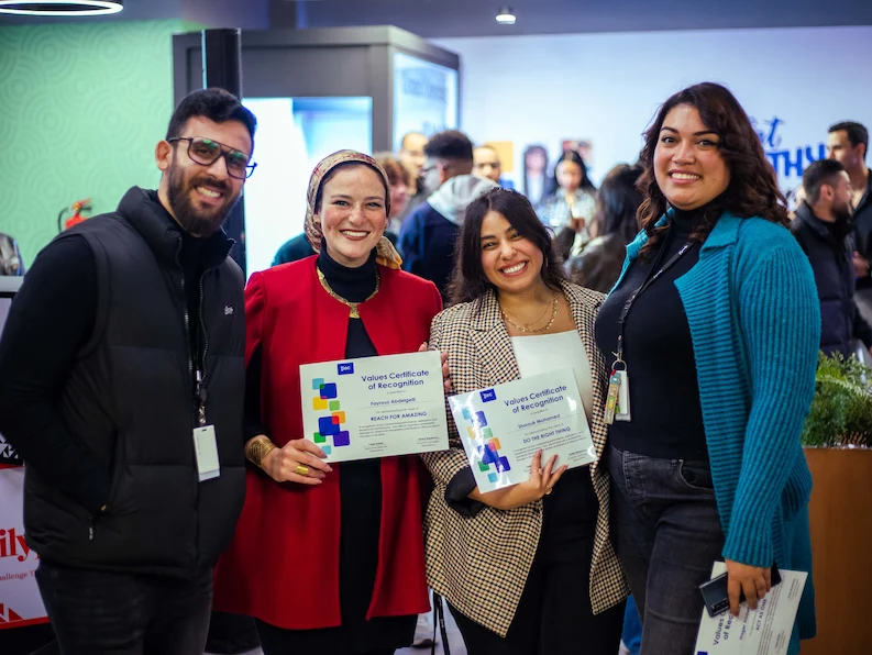 TTEC Egypt team members holding a certificate of recognition.