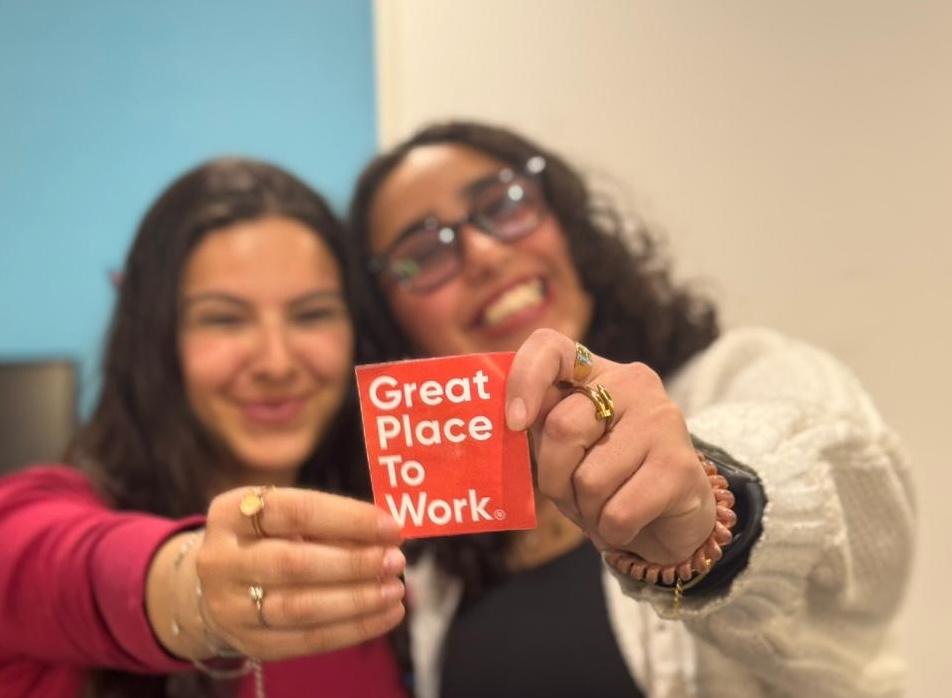 TTEC team members holding a Great Place to Work seal