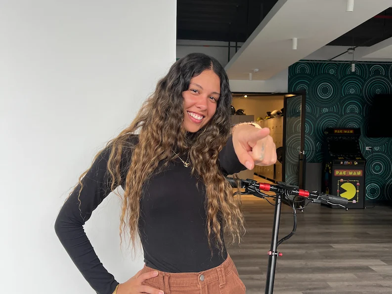 A happy employee pointing to the camera.