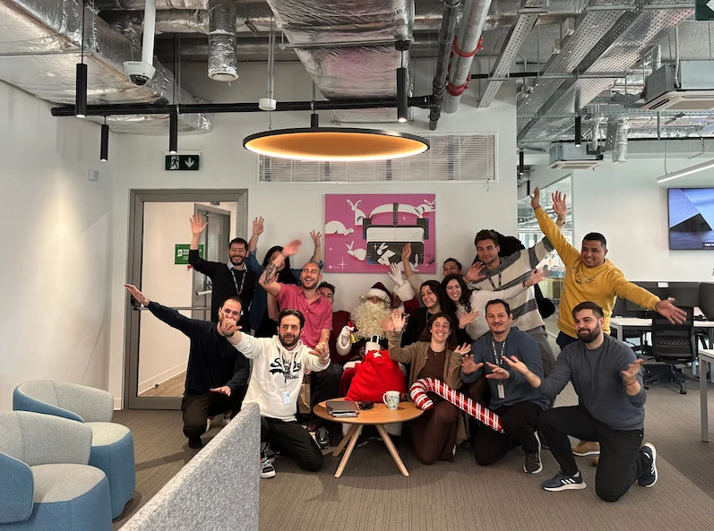A team at TTEC Athens posing joyfully during a Christmas event.