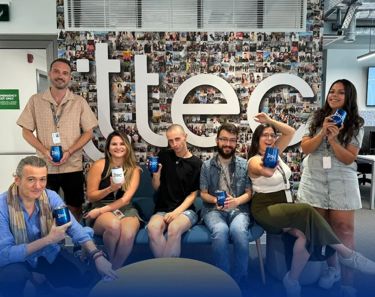 A team at TTEC posing for a picture while holding TTEC tumblers.