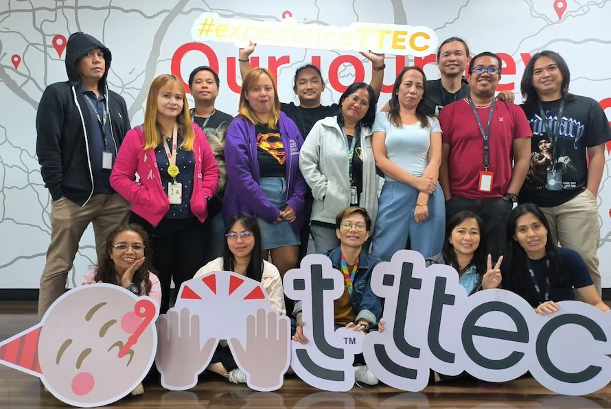 TTEC team holding fun signs and posing for a picture.
