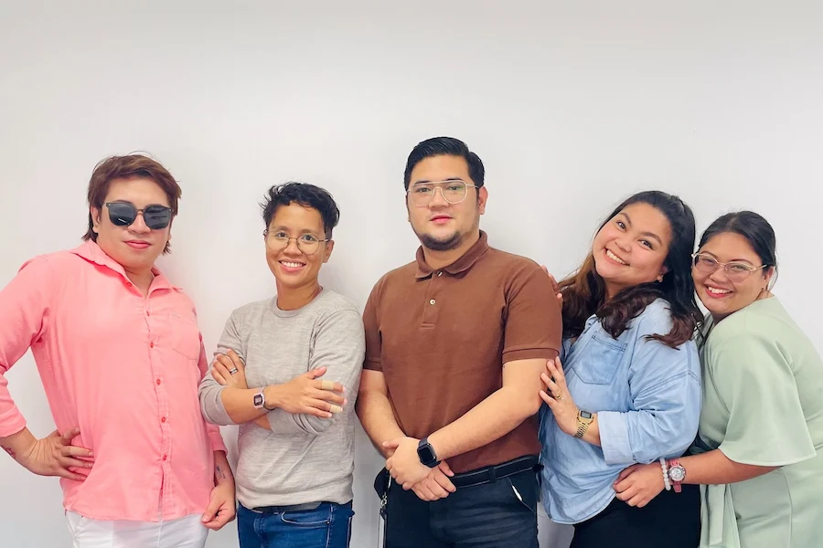 Five TTEC employees posing for a candid photo.