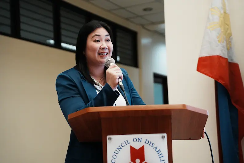 Natni Badiola, TTEC People & Culture Senior Manager and Global ERG Lead for PWD, speaks at the podium during the inclusive job fair, addressing the audience with passion and purpose.