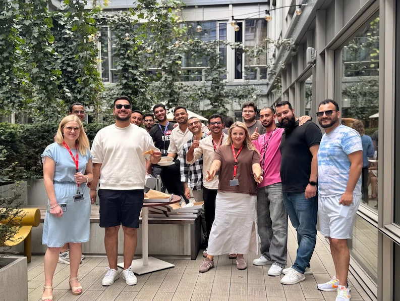 TTEC Poland employees eating pizza outside the office.