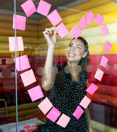 Business Woman at wall with sticky notes