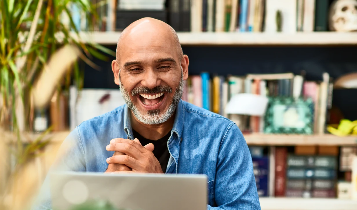 Man in home office sitting at table using a laptop