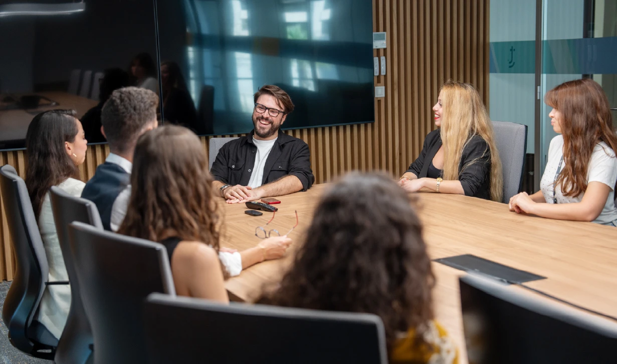 Two employees working in front of TTEC mural