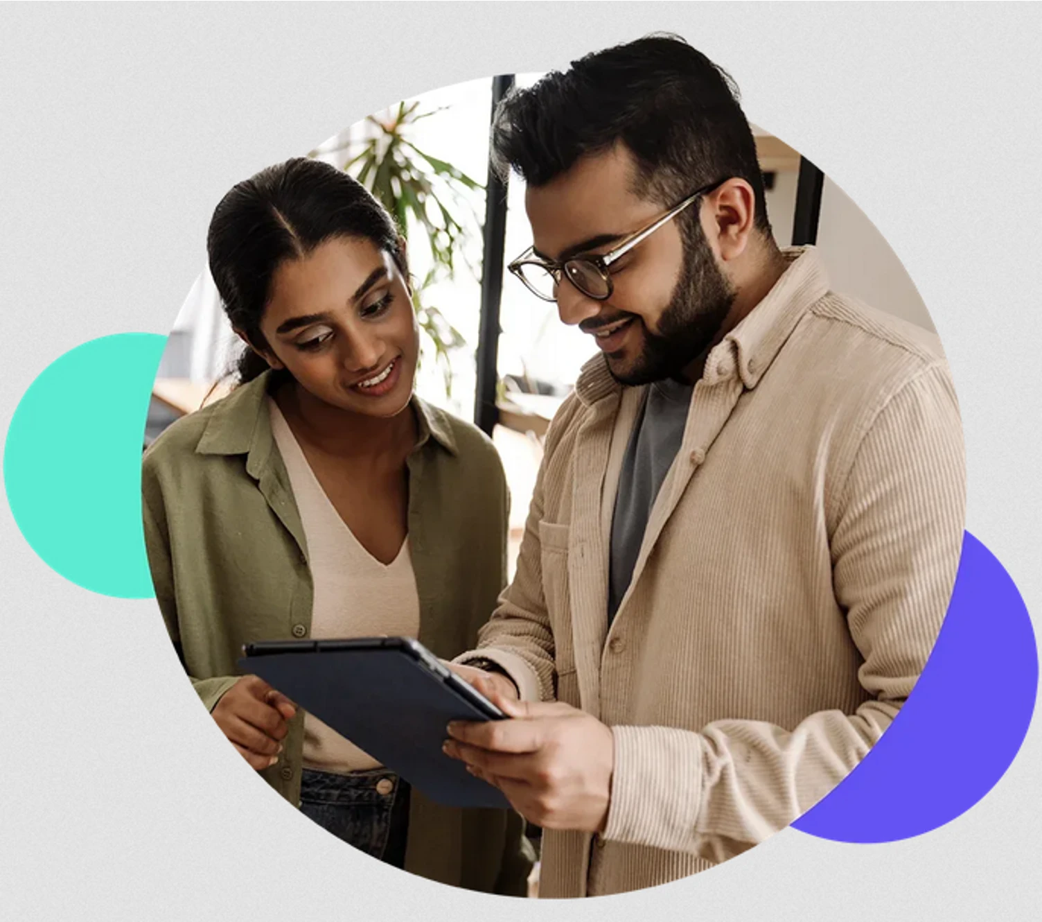 Two TTEC employees looking at a digital notepad.