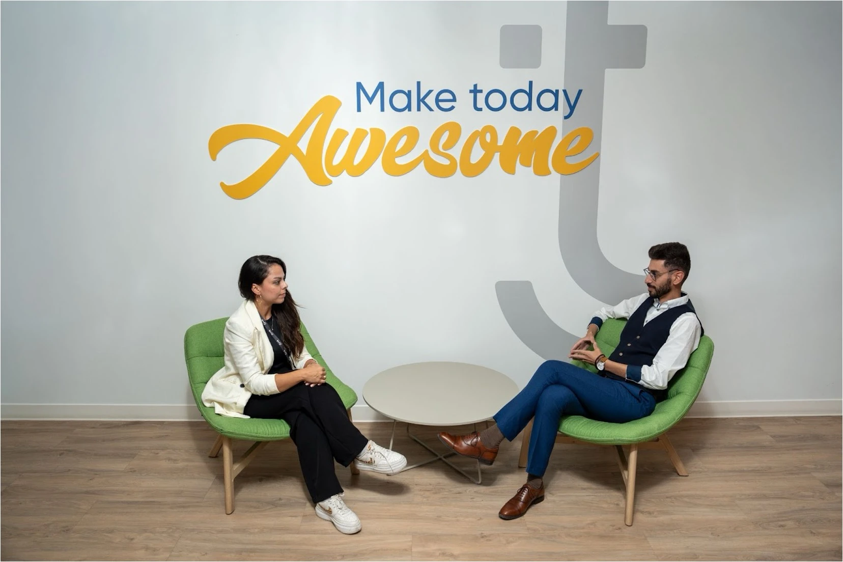 Two colleagues having a conversation in a modern office space.