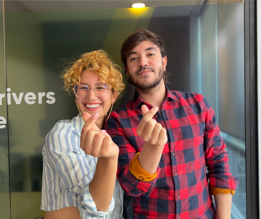 Two TTEC employees making peace sign gestures with their hands.