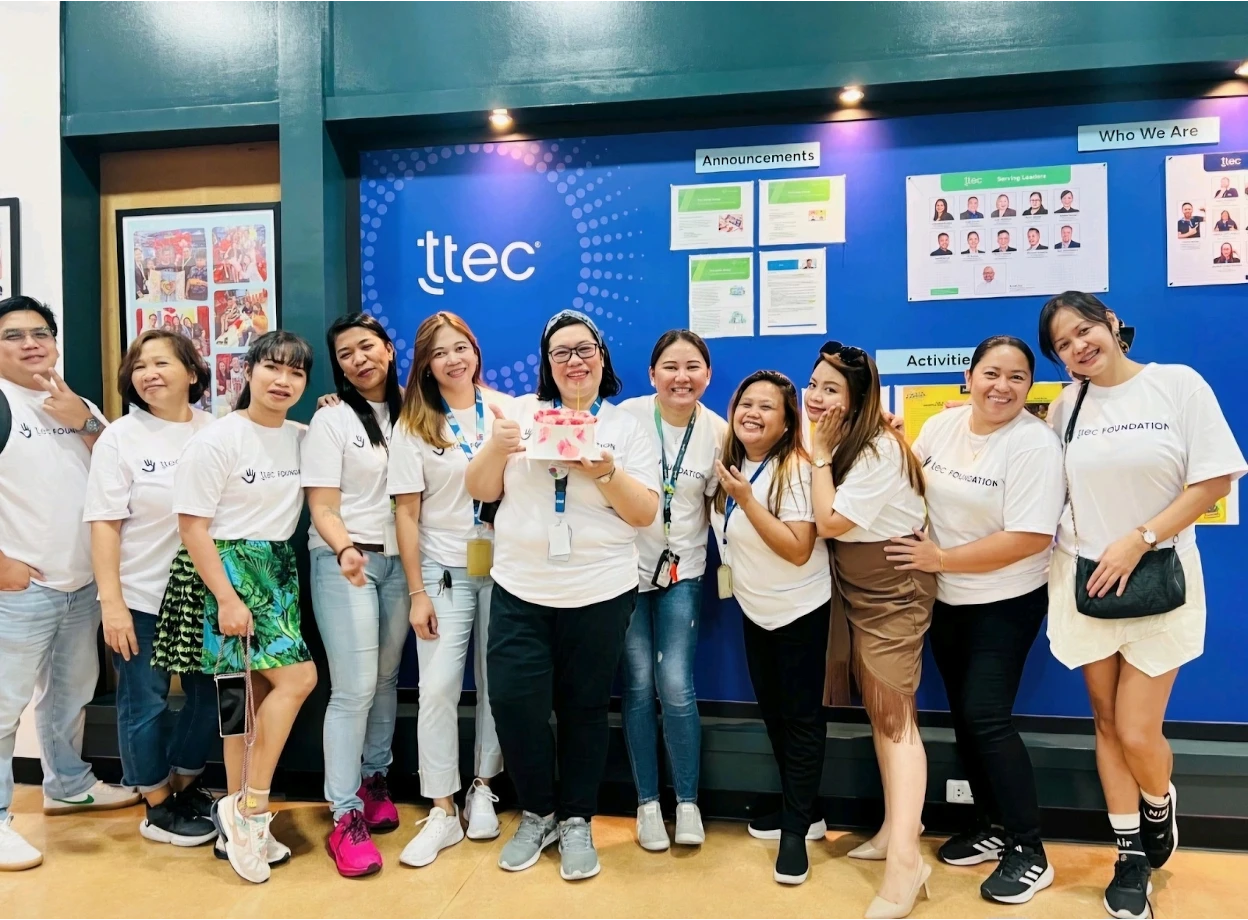 Group of TTEC employees in matching white foundation t-shirts.