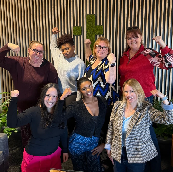Group of TTEC team members flexing and celebrating together.