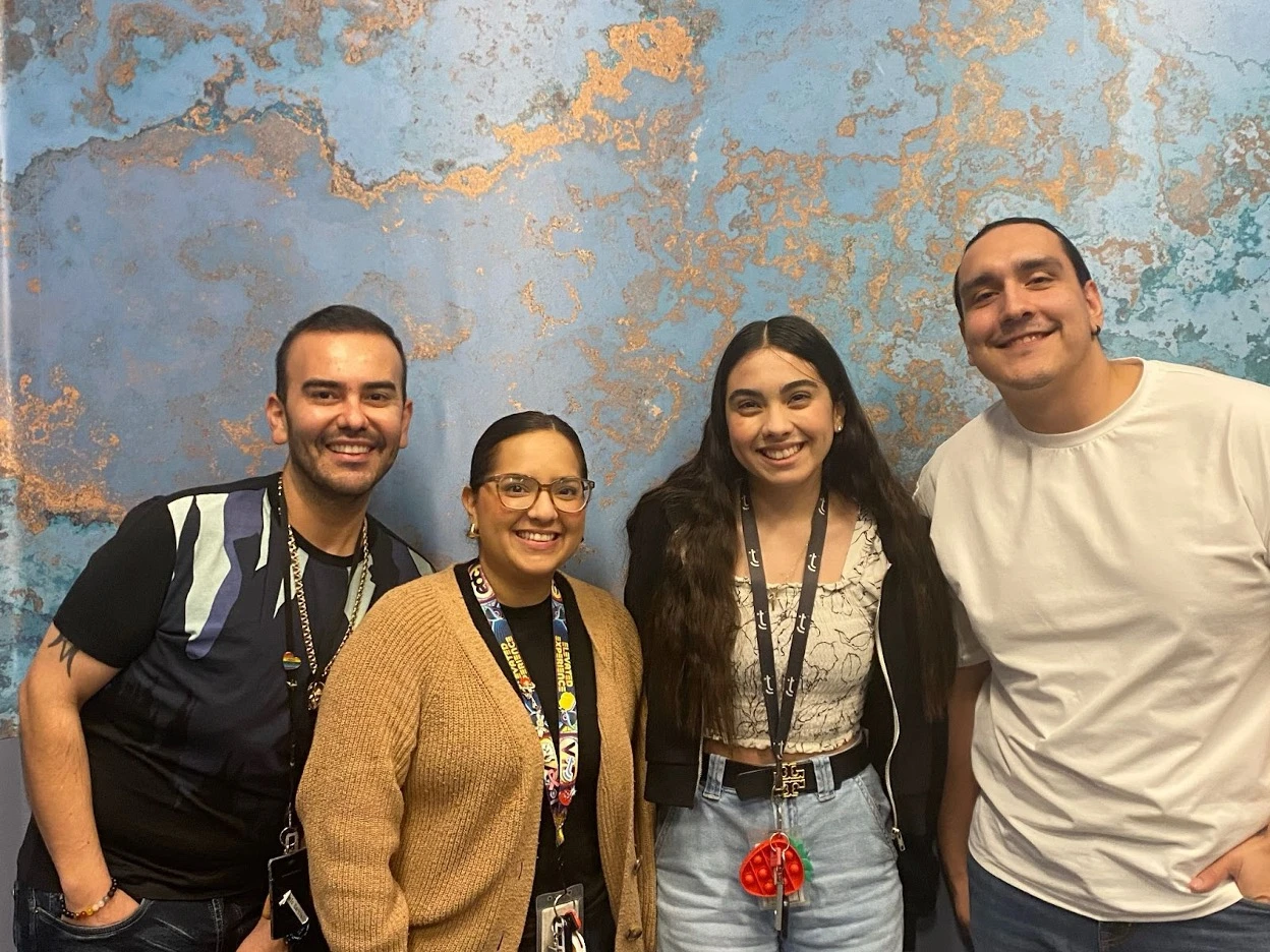 Four TTEC employees smiling and posing together.