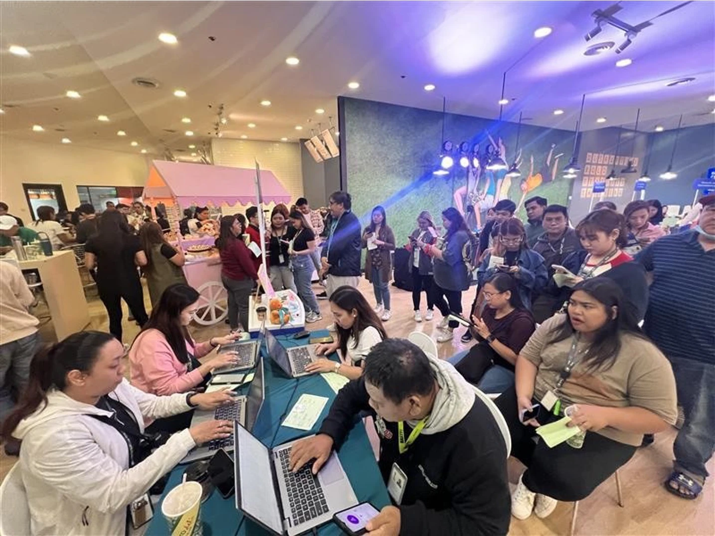 TTEC Philippines staff assisting job applicants on laptops during a recruitment event