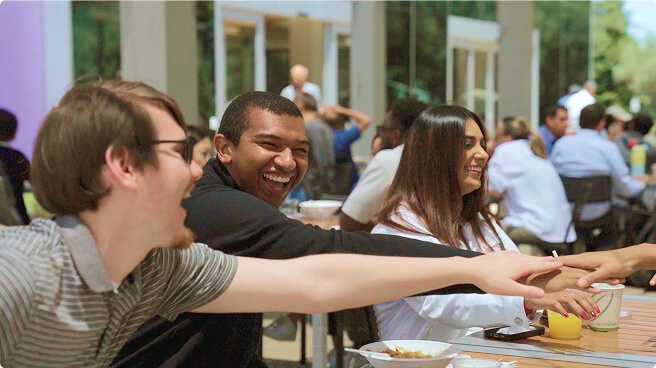 People sitting at table with their hands in the middle