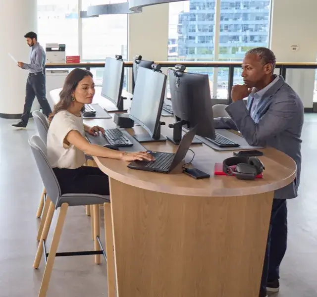 Two people working at their desk at the Staples Corporate office