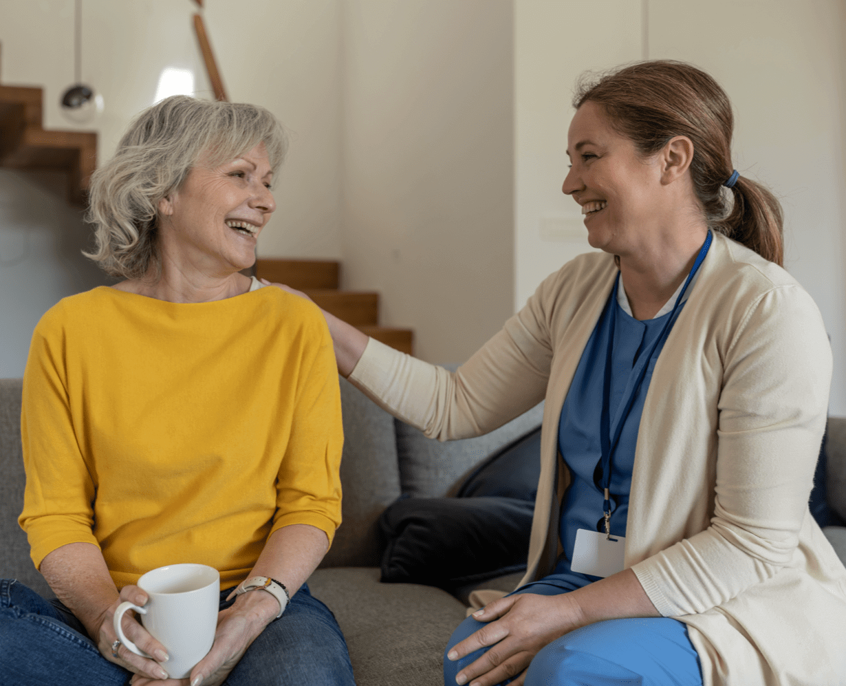 Two women having tea together on a sofa