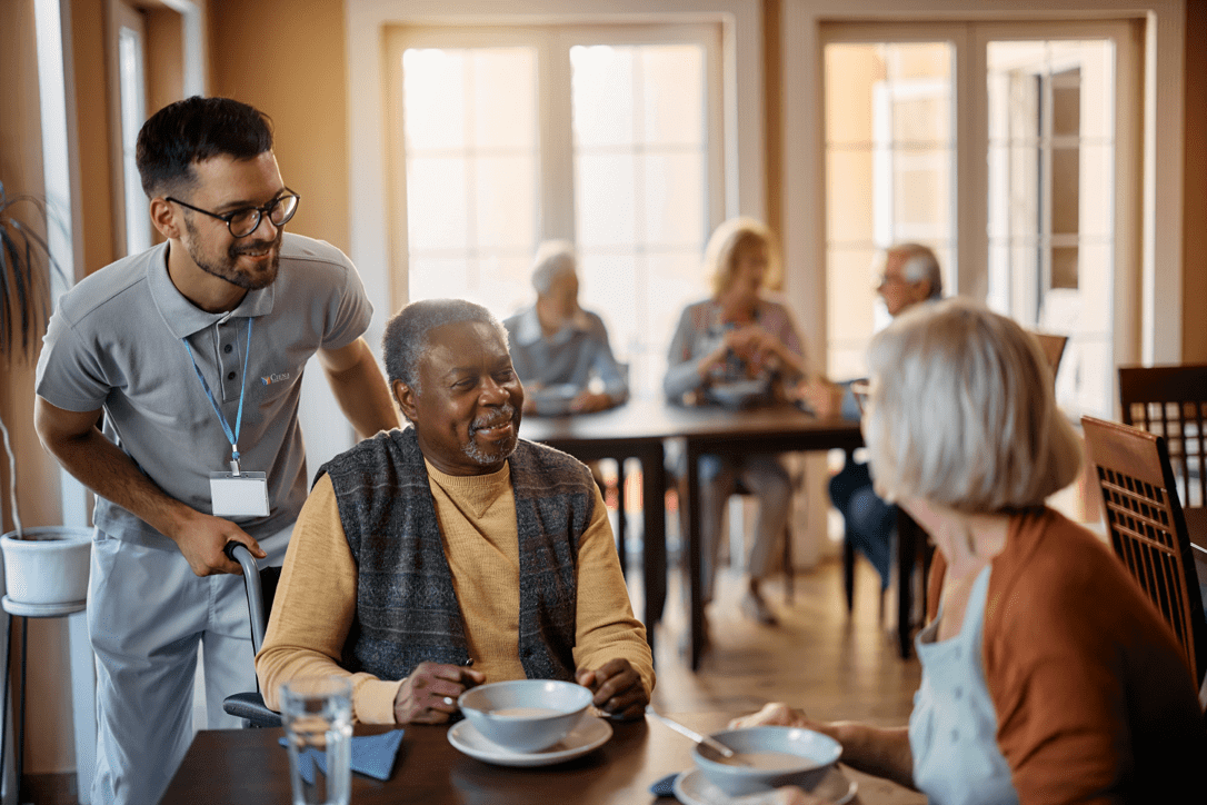 Ciena employee talking to residents at a dining table.